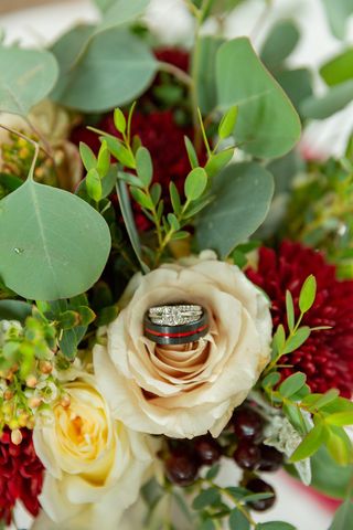 bouquet of beautiful flowers with wedding rings on top