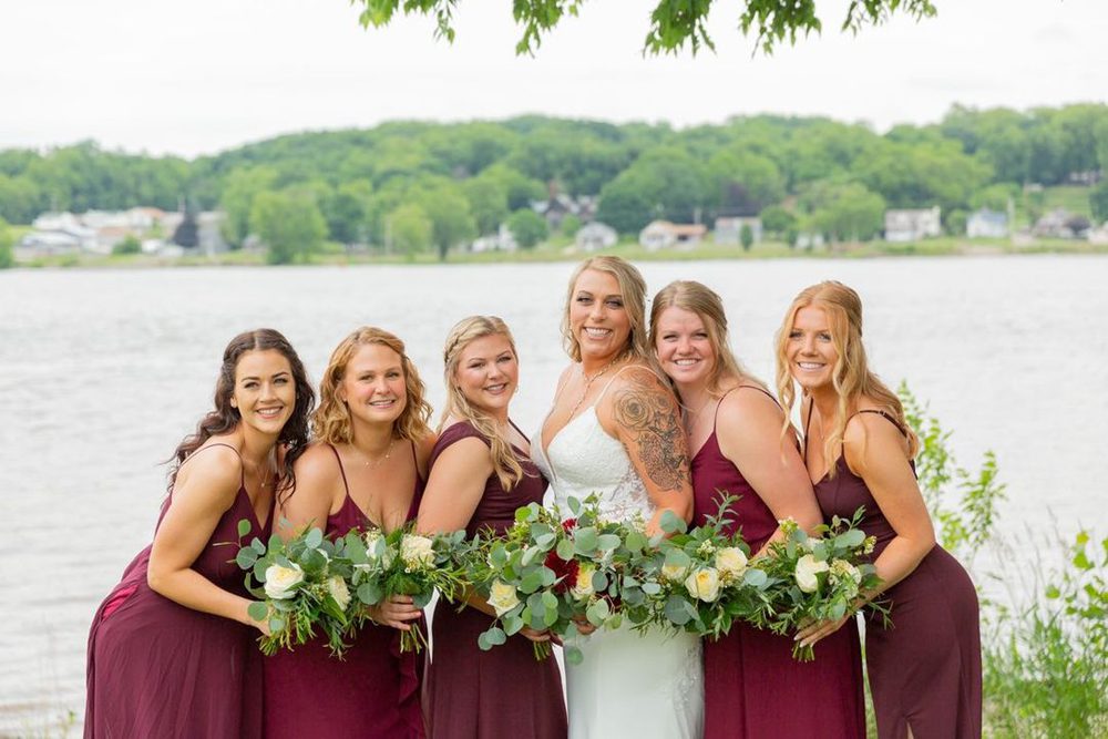 bride with her bridesmaid wearing a maroon dress
