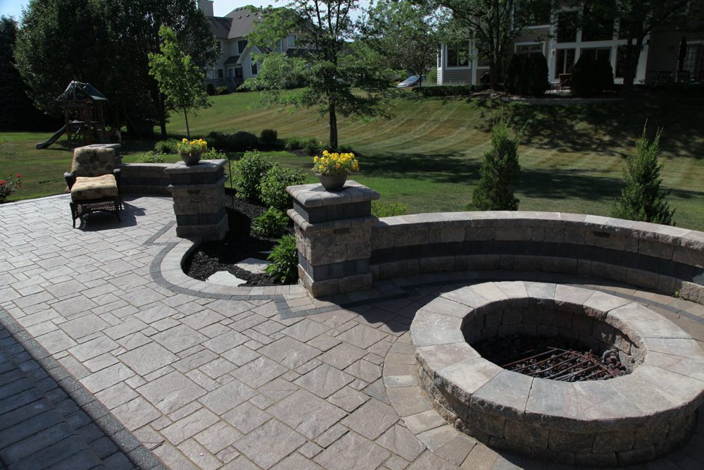 An empty patio chair sits close to a backyard firepit An empty patio chair sits close to a backyard firepit