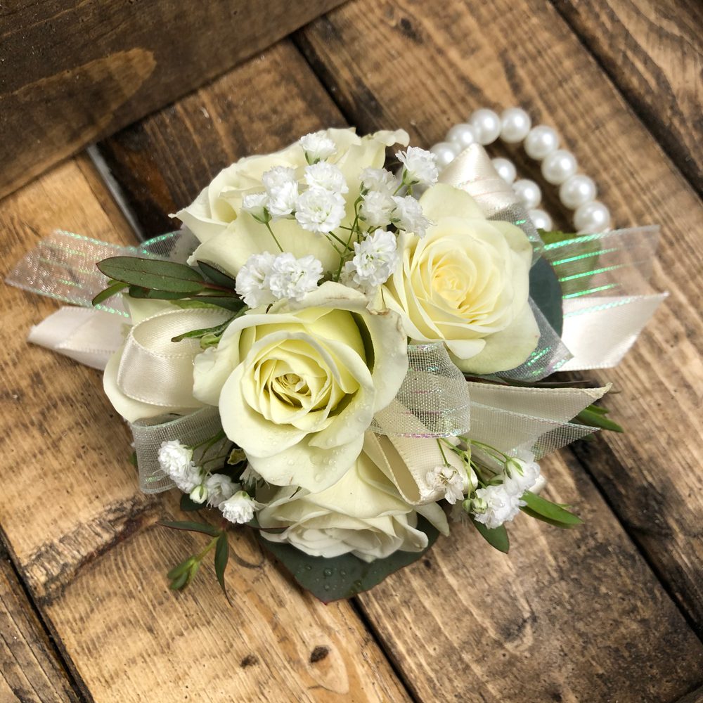 bouquet of white flowers and roses placed on wooden planks