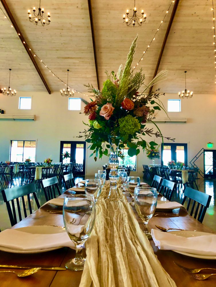 flowers arranged on a long dining table's center