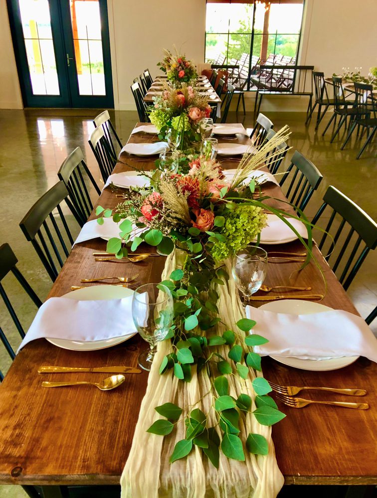 closeup shot of table settings with beautiful flower arrangements at the center