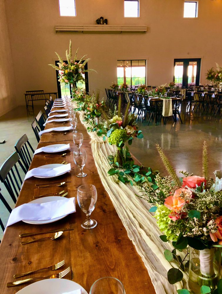 long wooden table with flower arrangements