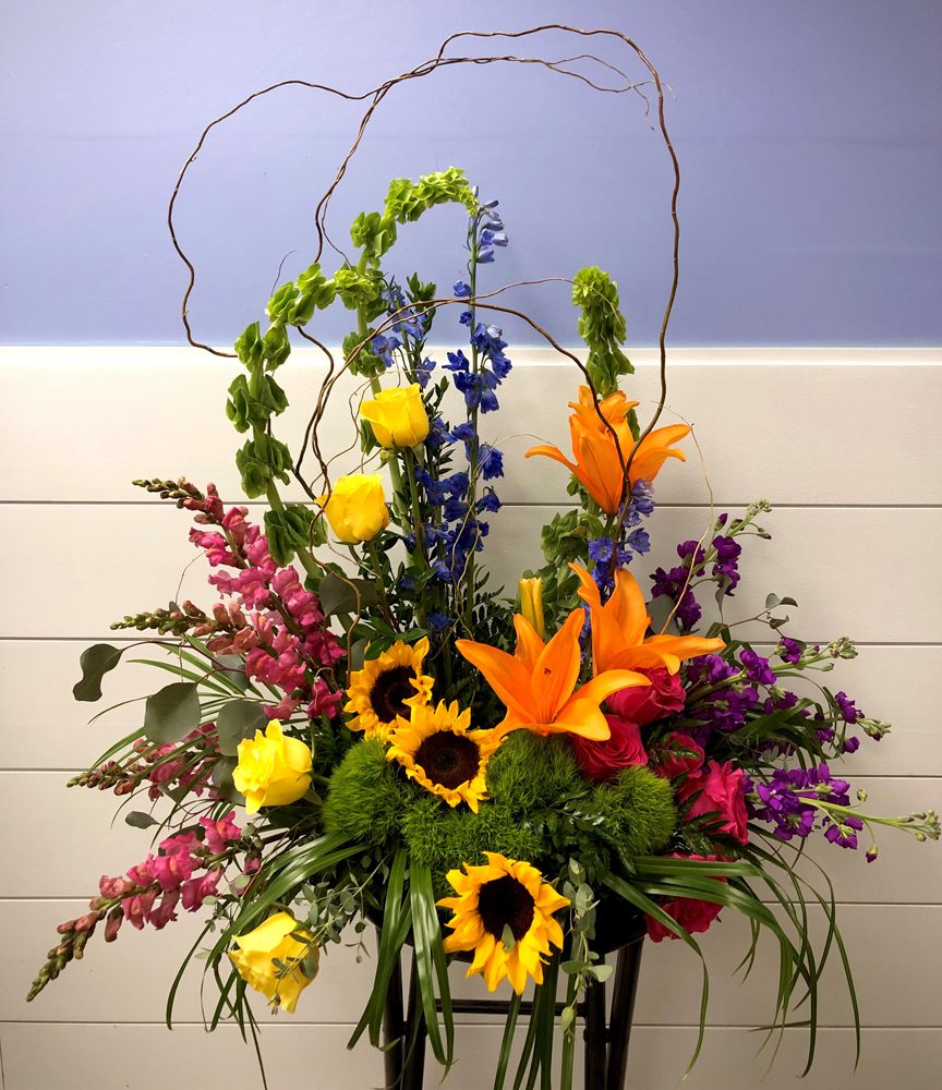 yellow, pink, blue, violet flowers bundled on a flower stand