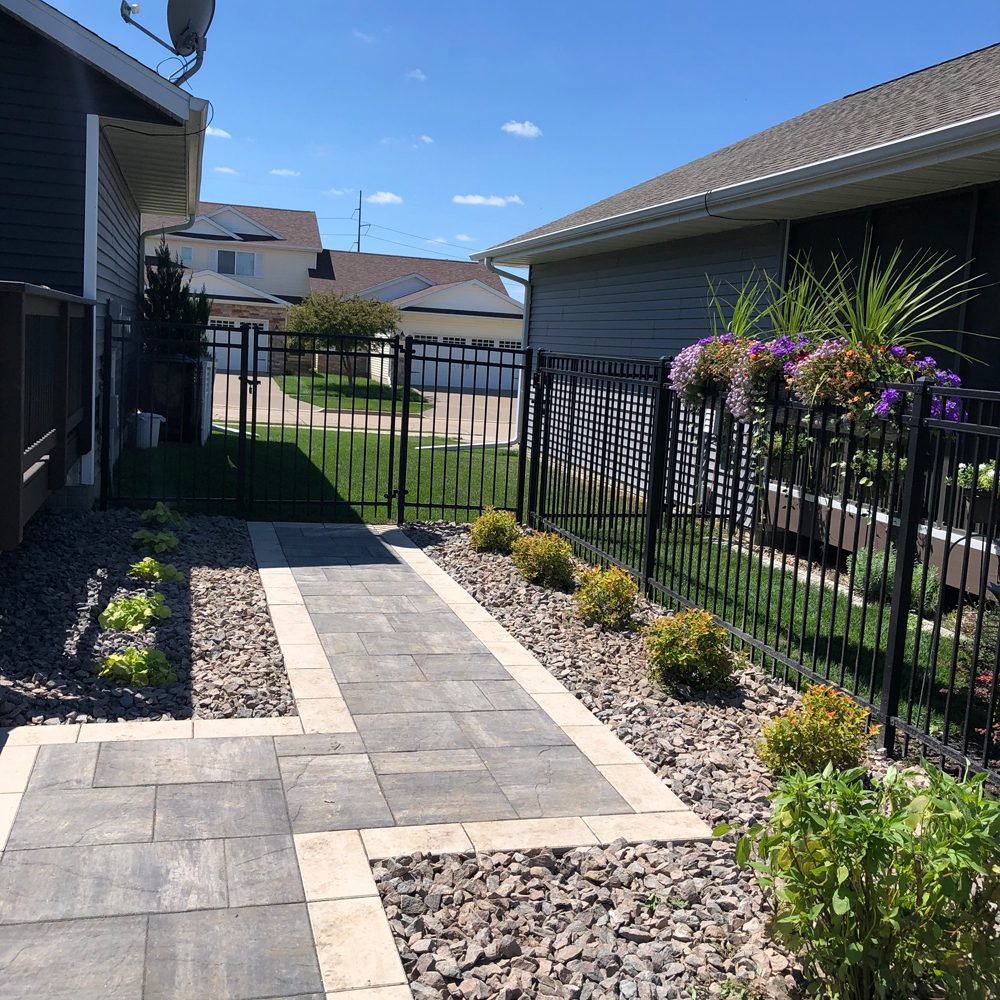 Walkway with pebble stones and garden plants beside it Walkway with pebble stones and garden plants beside it