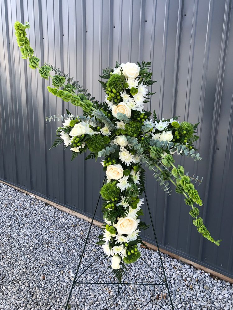 white flowers and green leaves bundled on a stand